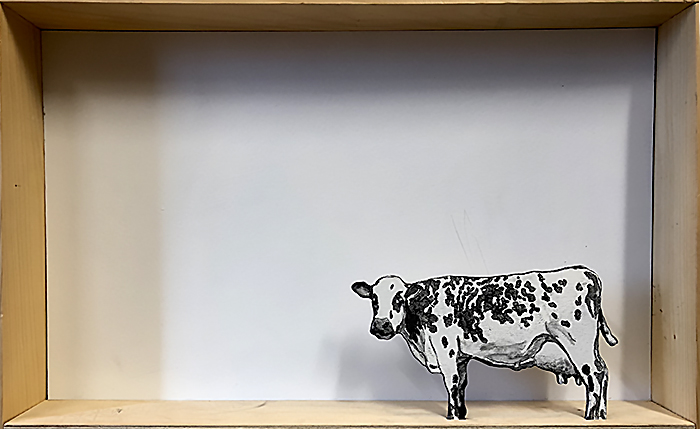 Petite vache peinte placée dans une boîte vide pour test de composition