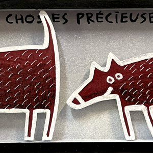 Deux chiens stylisés rouges en bois découpé face à face avec texte évoquant des choses précieuses