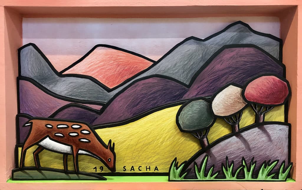 Diorama représentant une biche stylisée dans un paysage de collines colorées et montagnes graphiques, en acrylique sur bois
