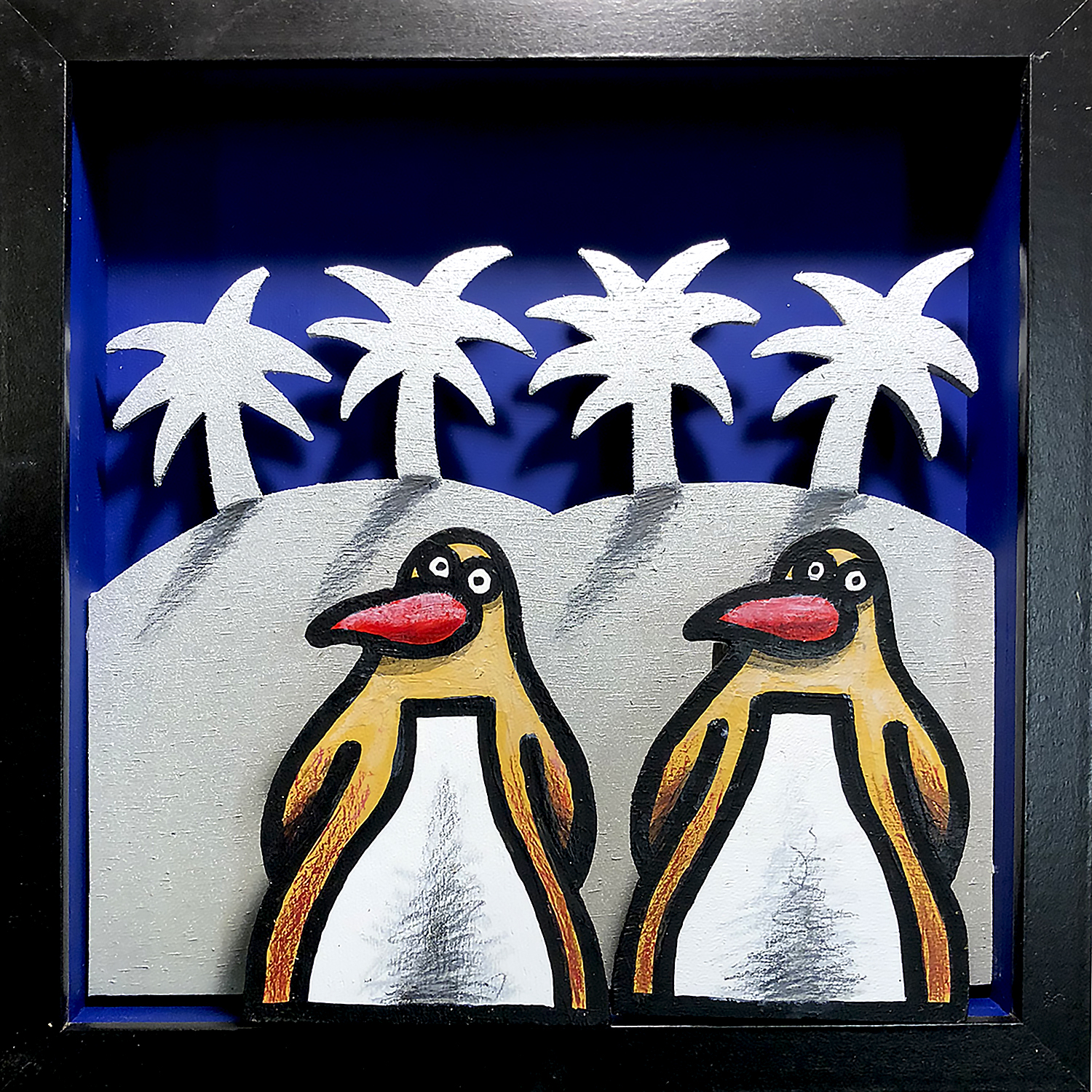 Diorama représentant deux pingouins stylisés devant des palmiers, en acrylique sur bois