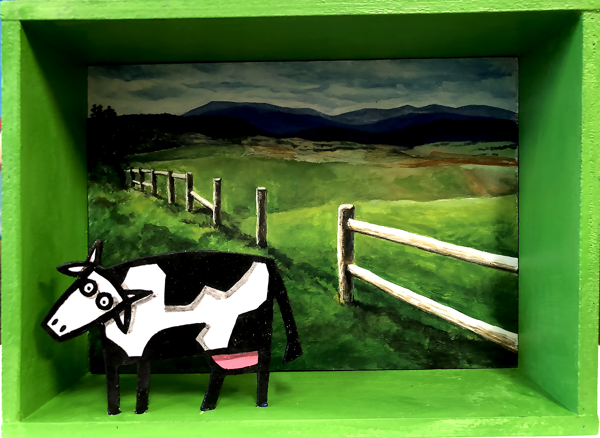 Diorama représentant une vache devant un paysage de prairie avec clôture et collines, en acrylique sur bois