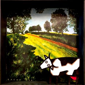 Diorama représentant une vache stylisée devant un paysage réaliste avec chemin lumineux et arbres, en acrylique sur bois
