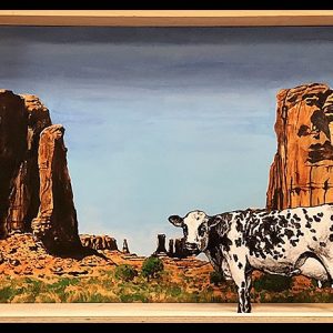 Diorama représentant une vache devant un paysage rocheux désertique aux formations monumentales, en acrylique sur bois