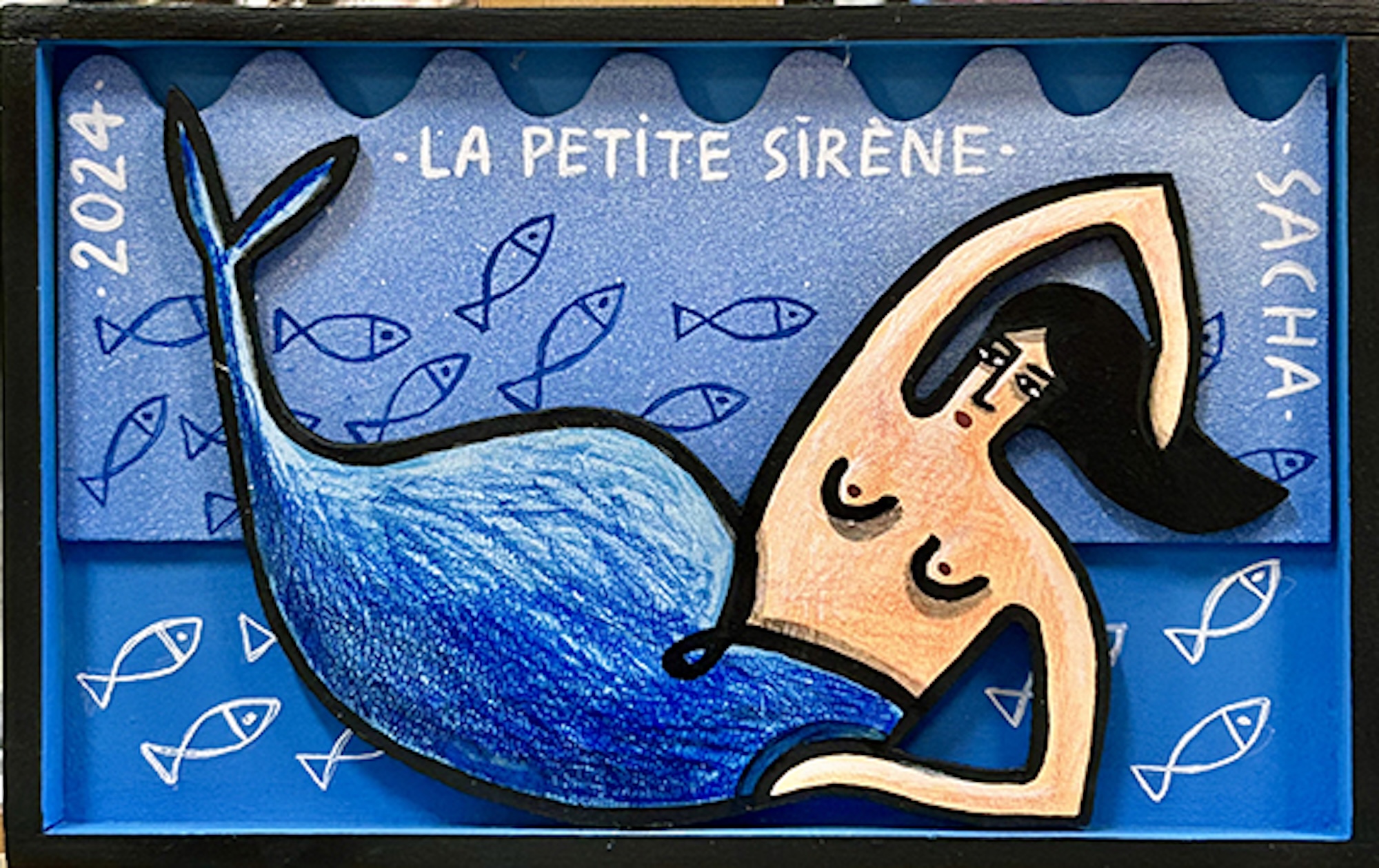 Sirène stylisée en bois découpé allongée sur fond bleu avec motifs de poissons et texte, série Boîtes